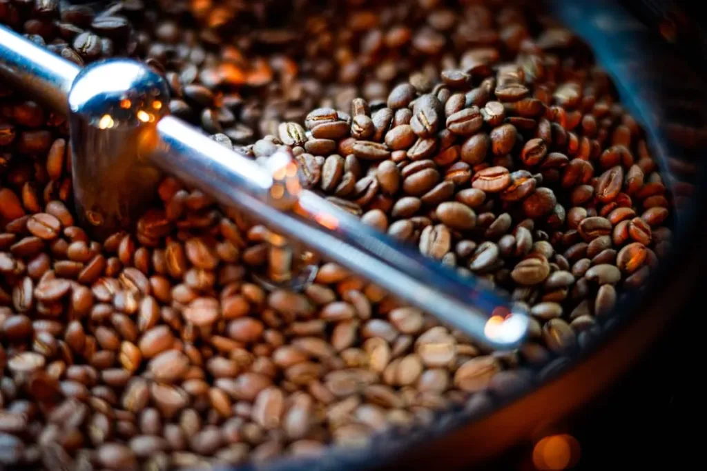 Boabe de cafea în tamburul unei mașini de prăjit